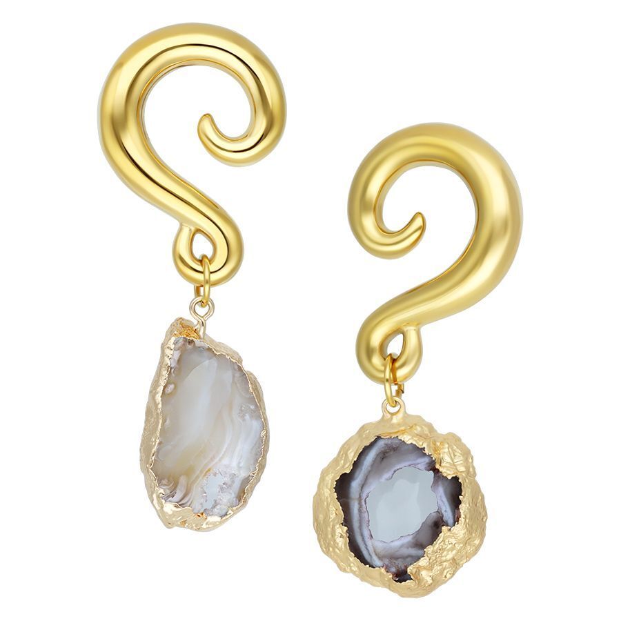 Kaksi kultaista intialaista akaatti korvakorua luonnonkivellä valkoisella taustalla