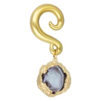 Kultainen korvapaino Indian Agate kivellä valkoisella taustalla