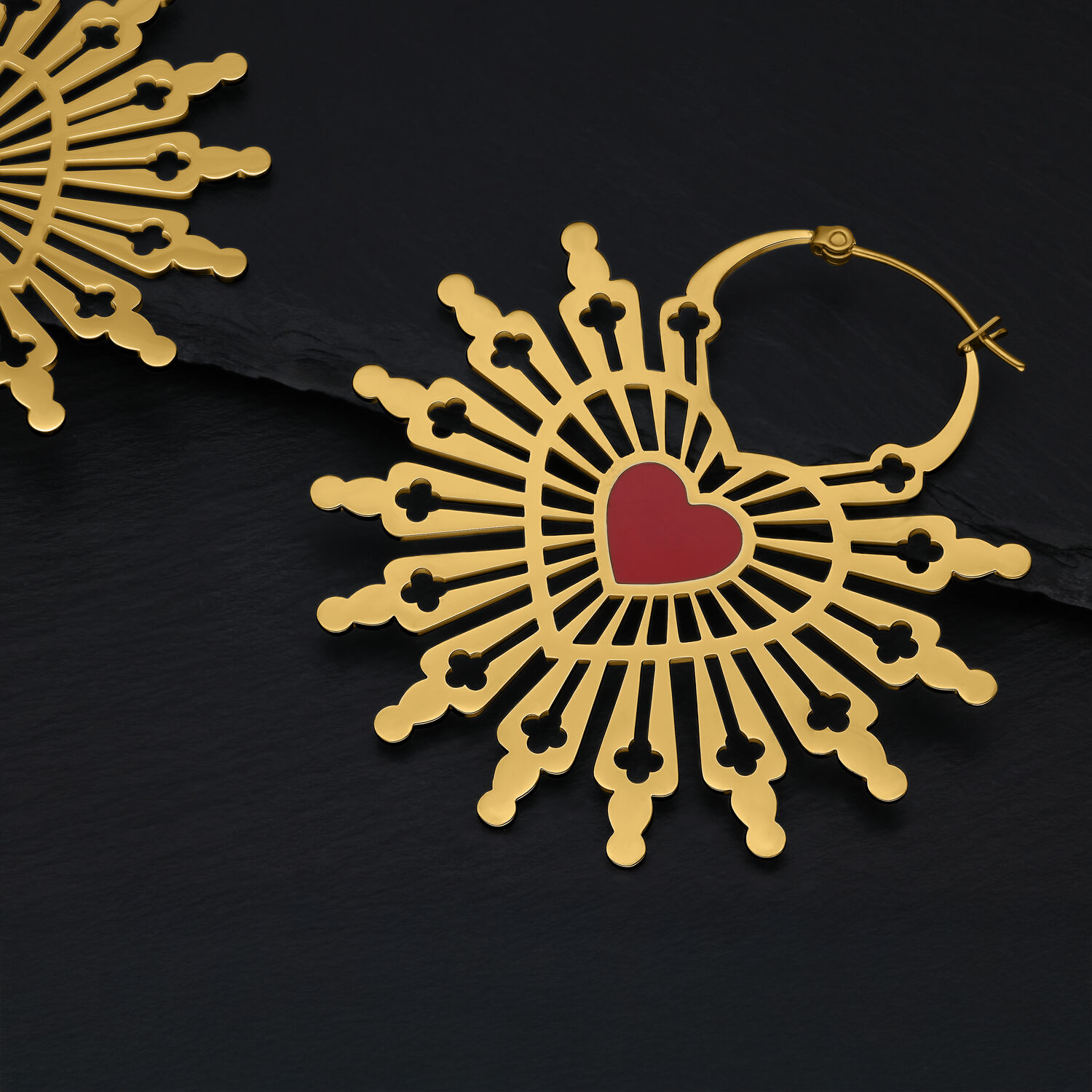 Goldene Sacred Heart Ohrringe Hoops Goldene Ohrringe in Herzform auf schwarzem Hintergrund