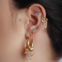 Goldene Glamour Hoops Ohrringe am Ohr einer Person mit weiteren Piercings