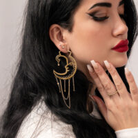 Frau mit goldenen Oldschool Sun Moon Hoops Ohrringen vor neutralem Hintergrund