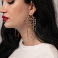 Frau mit langen schwarzen Haaren trägt roségoldene Sun Moon Hoops Ohrringe, seitliche Ansicht