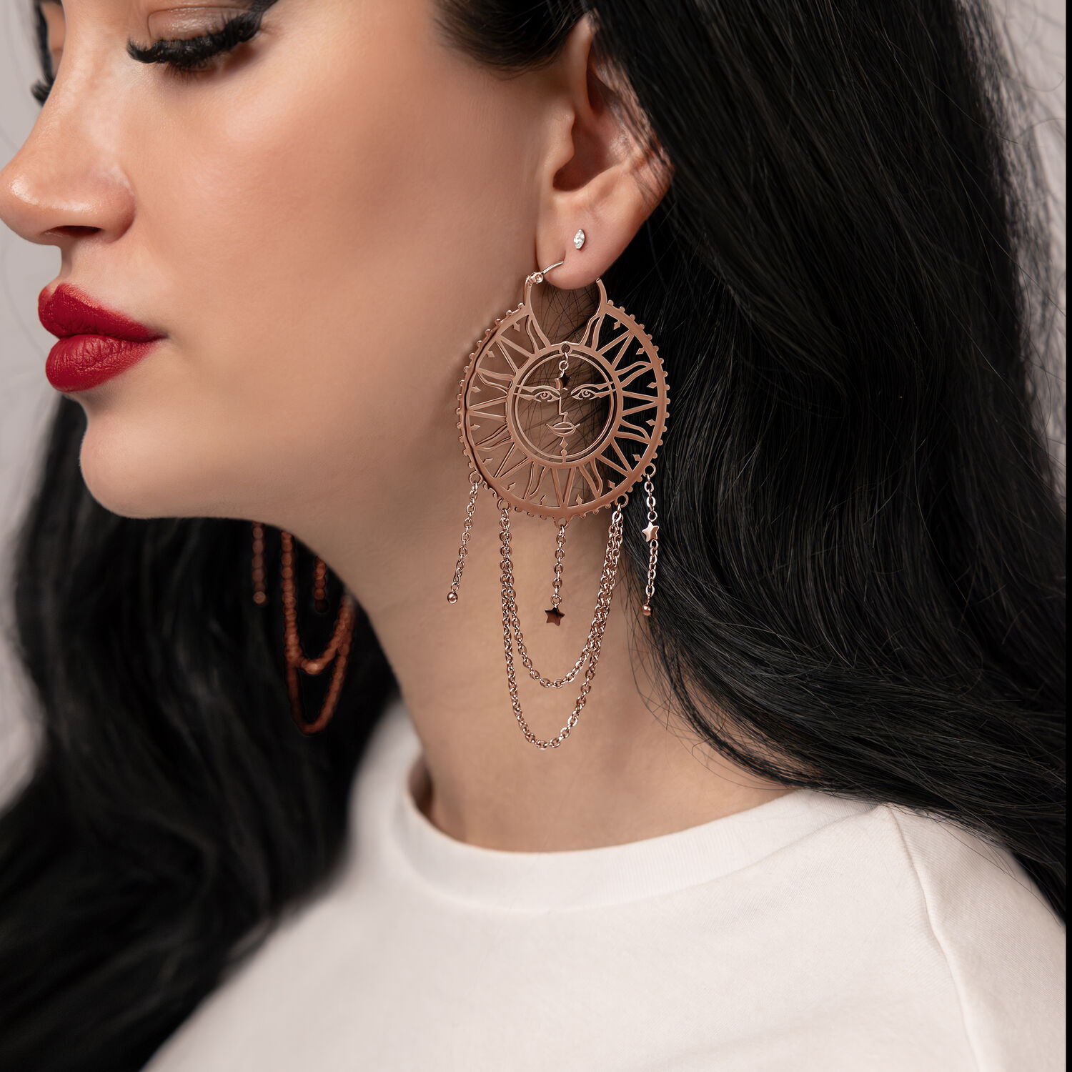 Frau mit langen schwarzen Haaren trägt roségoldene Sun Moon Hoops Ohrringe, seitliche Ansicht