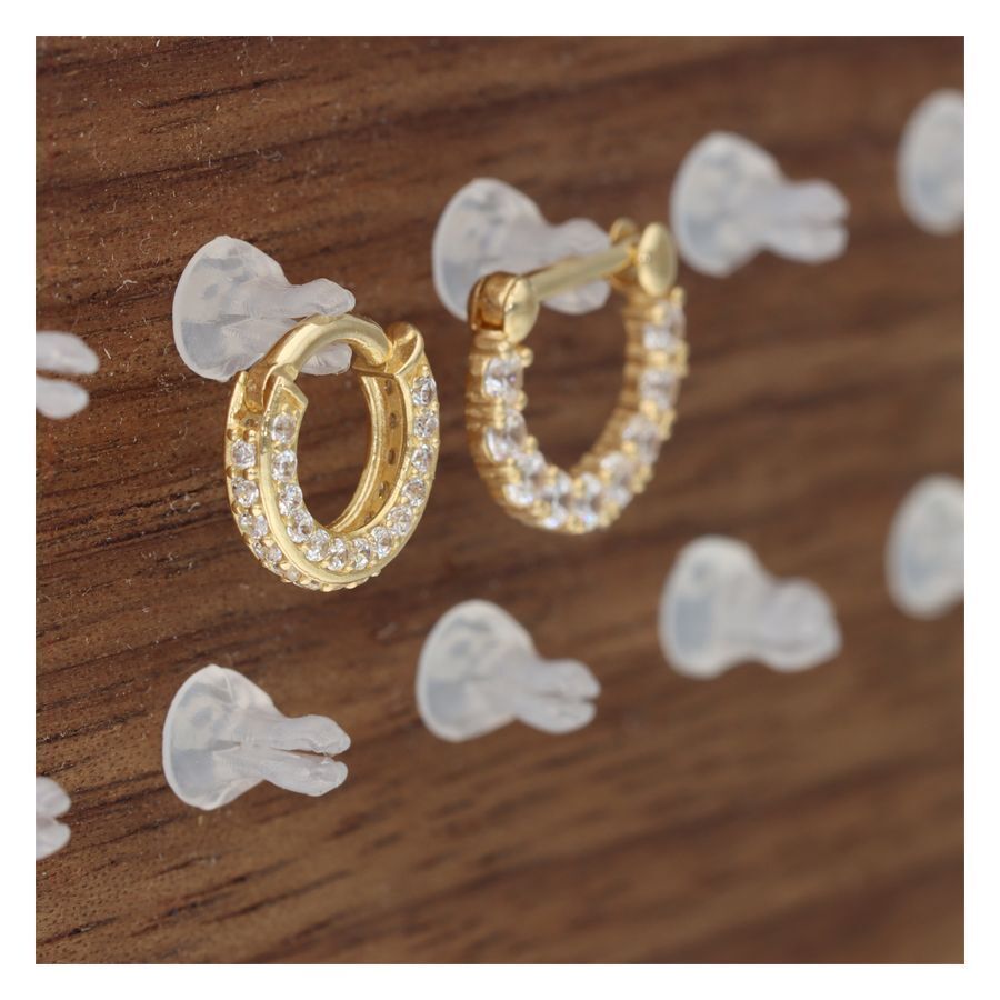 Goldener Clip an einem Holzdisplay mit PTFE-Material auf schlichtem Hintergrund