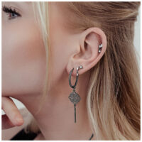 Schwarze Clover Hoops Ohrringe aus Chirurgenstahl am Ohr einer Frau