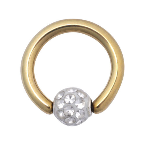 Kultainen klipsirengas kirkkailla kristalleilla valkoisella taustalla