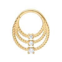 Kultainen lävistysrengas, jossa kolme kierrettyä riviä ja kirkkaita kristalleja