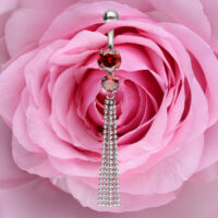 Hopeinen bananabelli punaisilla kristalleilla ja ketjuilla vaaleanpunaisella ruusulla