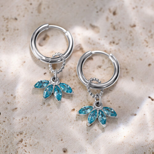 Kaksi hopeista rengasta turkooseilla kristalliriipuksilla vaalealla kivellä