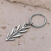 Hopeinen oksa-design korvakoru beigen kiven pinnalla