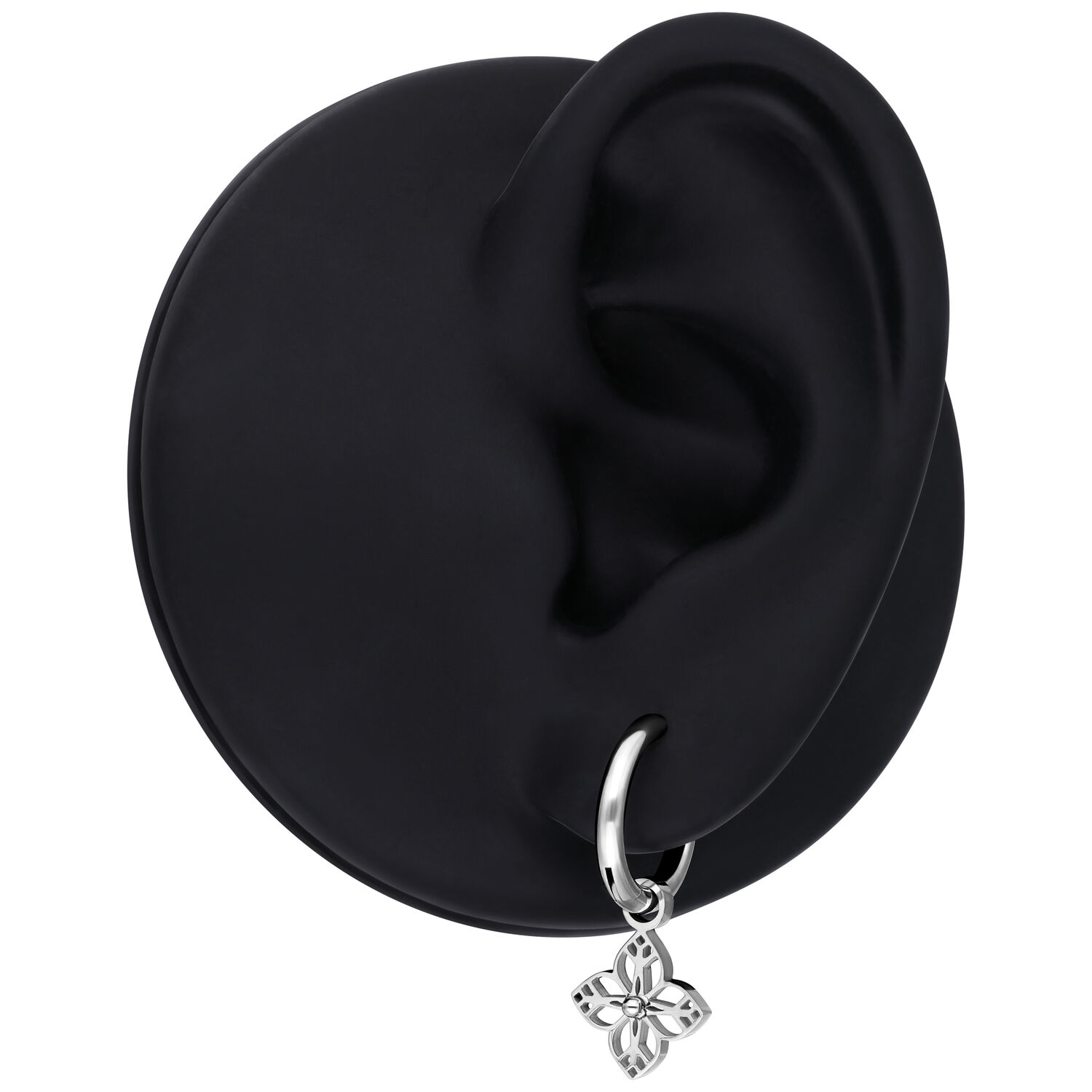 Hopeinen korvakoru pienellä kukkariipuksella, esitelty mustassa korvamallissa