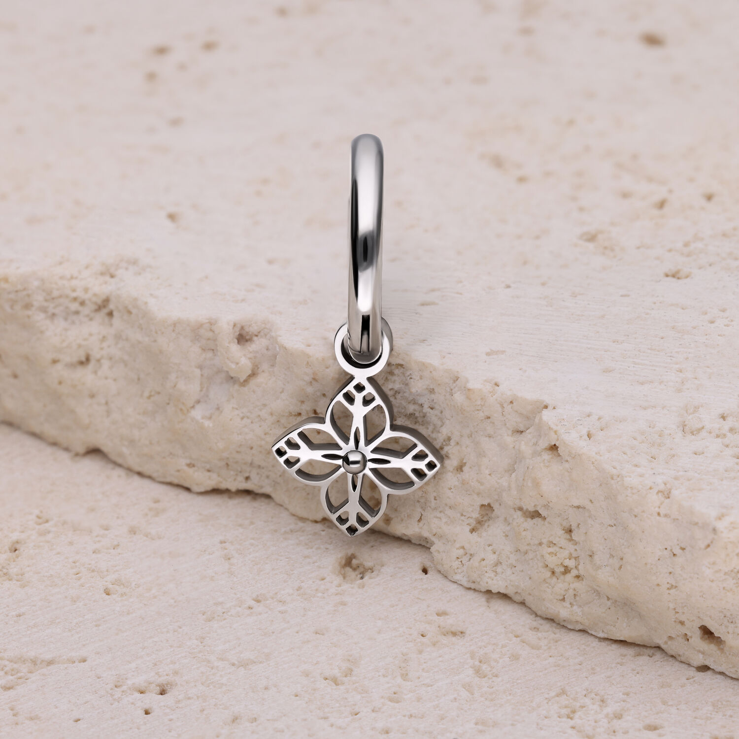 Hopeinen korvakoru kukkamuotoisella riipuksella vaalealla kivellä