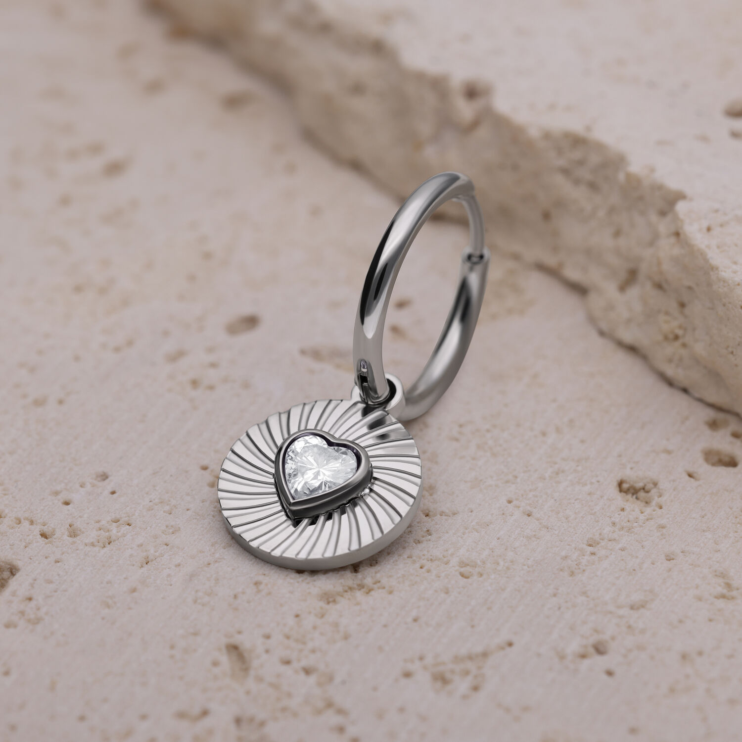 Hopeinen korvakoru sydämenmuotoisella riipuksella vaalealla kivellä