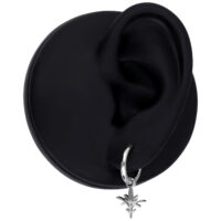 Musta korvakoru, jossa on pieni oksan muotoinen hopeariipus mustalla taustalla