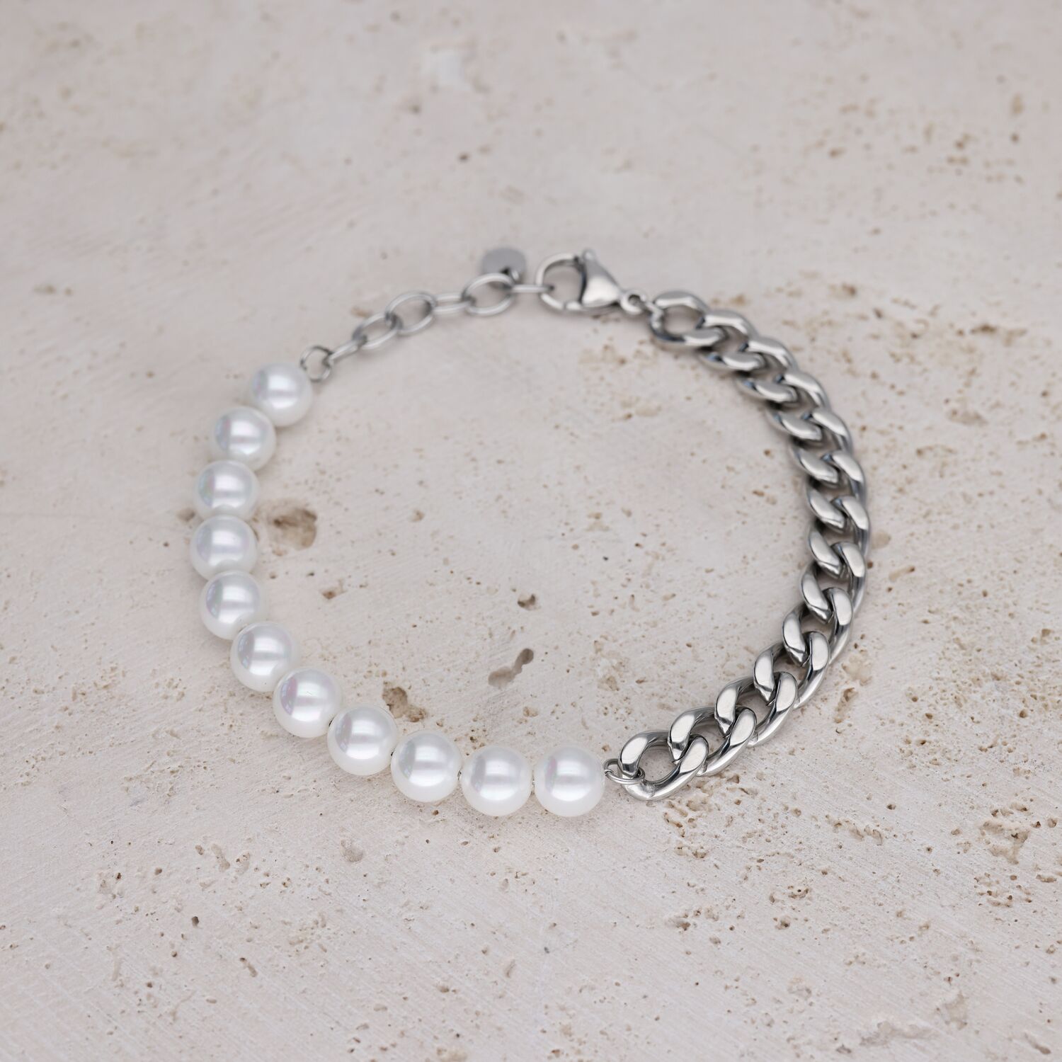 Rannekoru valkoisilla helmillä ja hopeisella ketjulla vaalealla kivellä