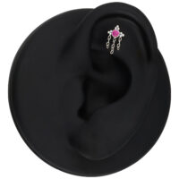 Hopeinen korvakoru punaisella kristallilla ja ketjuilla mustassa mallikorvassa