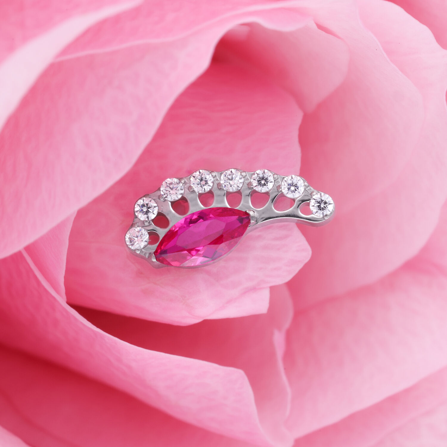 Hopeinen lisäosa, jossa on ovaali punainen kristalli vaaleanpunaisella terälehdellä