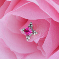 Hopeinen ornamenttilisäosa punaisella kristallilla vaaleanpunaisilla terälehdillä