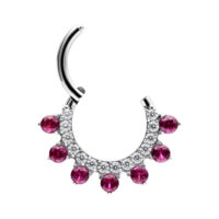 Hopeinen lävistysrengas punaisilla kristalleilla valkoisella taustalla